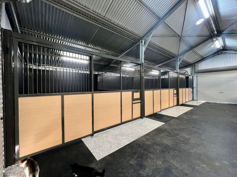 Completed stable fitout with steel stall fronts and timber infill