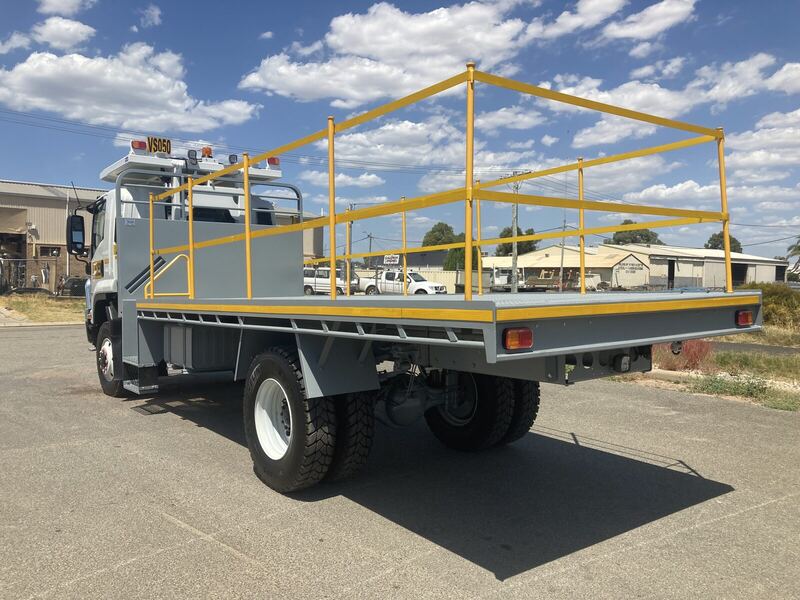 Truck tray fitted with yellow fold-down safety rails